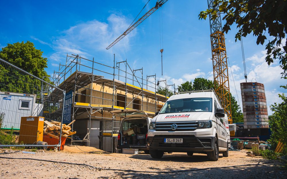 Holzrahmenbau-Baustelle mit Boysen-Fahrzeug und Kran